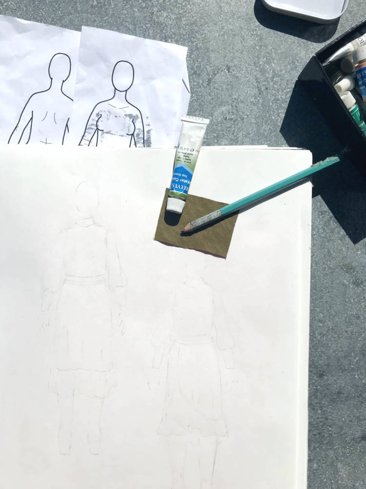 Amanda's sketching process involves sketches on her MyBodyModel croquis in mechanical pencil, an eraser to erase the pencil if adding color, coloring tools like watercolors, and a fabric swatch to find the best color for each garment.