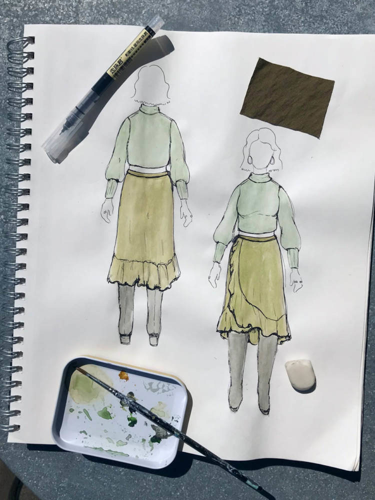 Amanda uses a fine line pen over her colored MyBodyModel croquis sketches to add depth and detail. Pictured is Amanda's front and back croquis sketch of a green Frankie skirt and matching green sweater from her closet, a pen, a watercolor palette, and a reference fabric swatch.